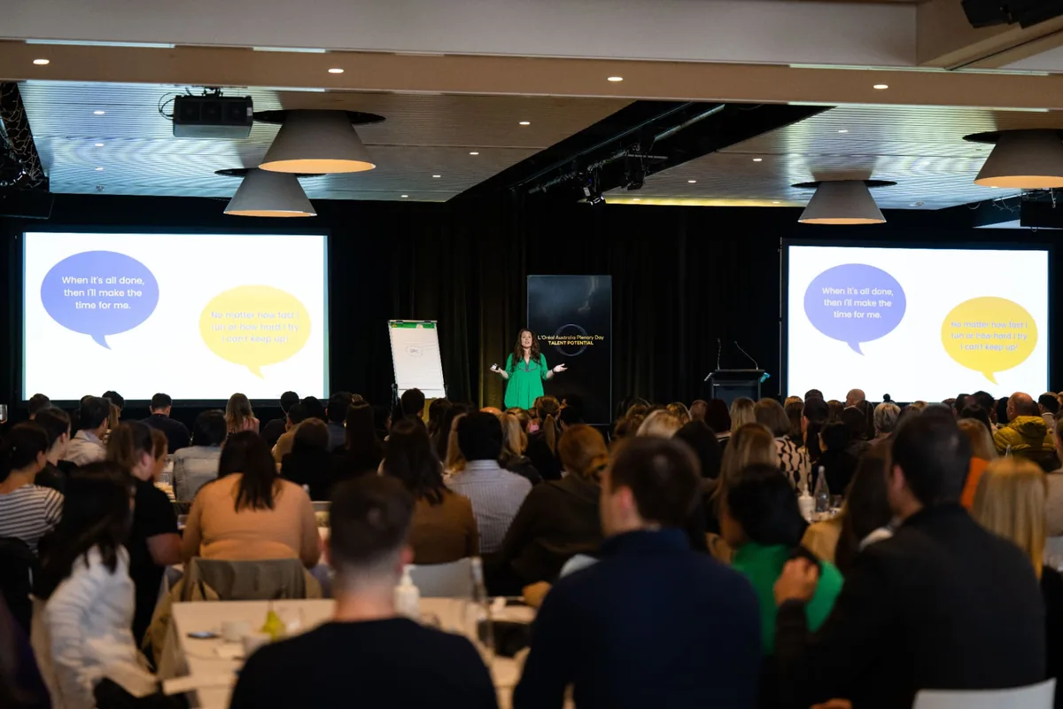 Penny Locaso delivering a keynote to a large audience